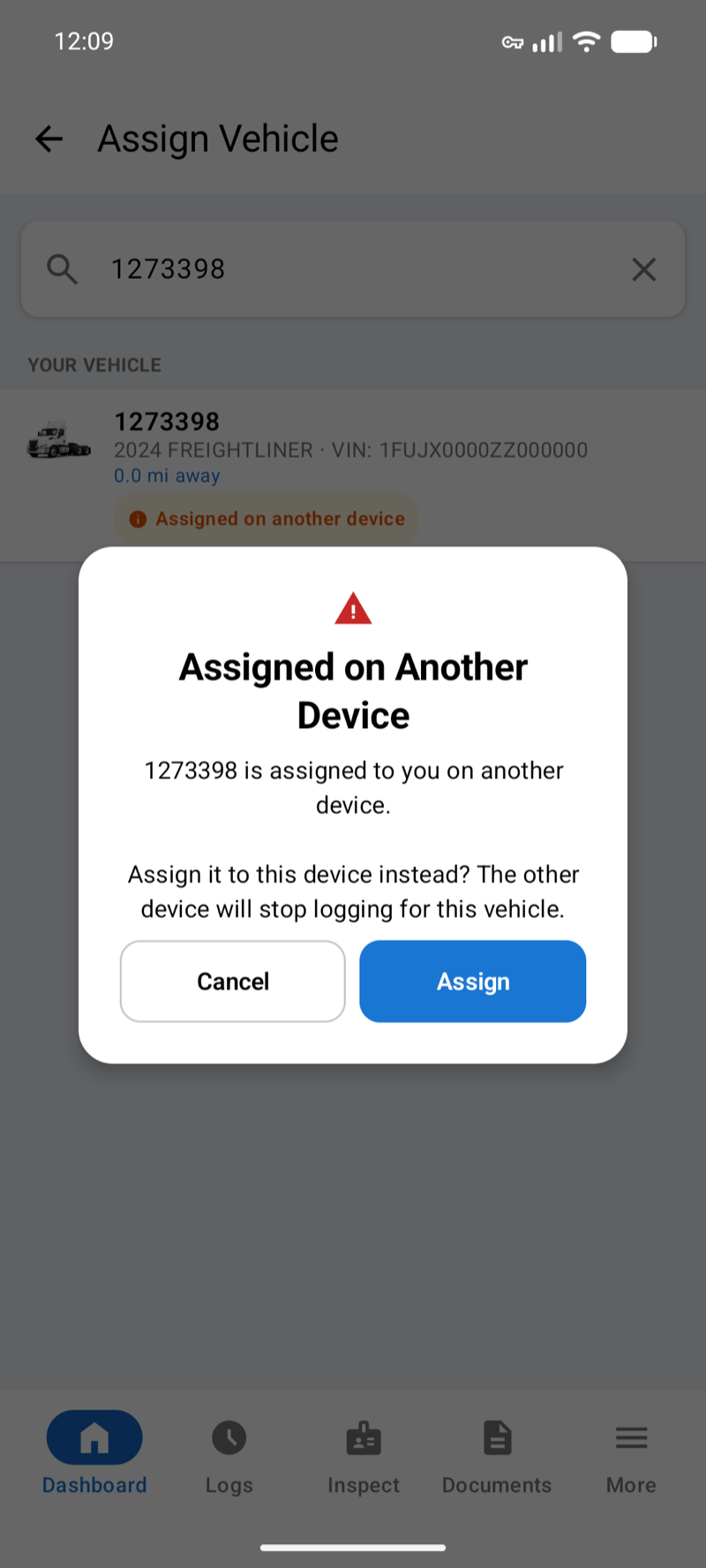 Assigned on Another Device message asking to assign the vehicle to this device instead, with Cancel and Assign buttons